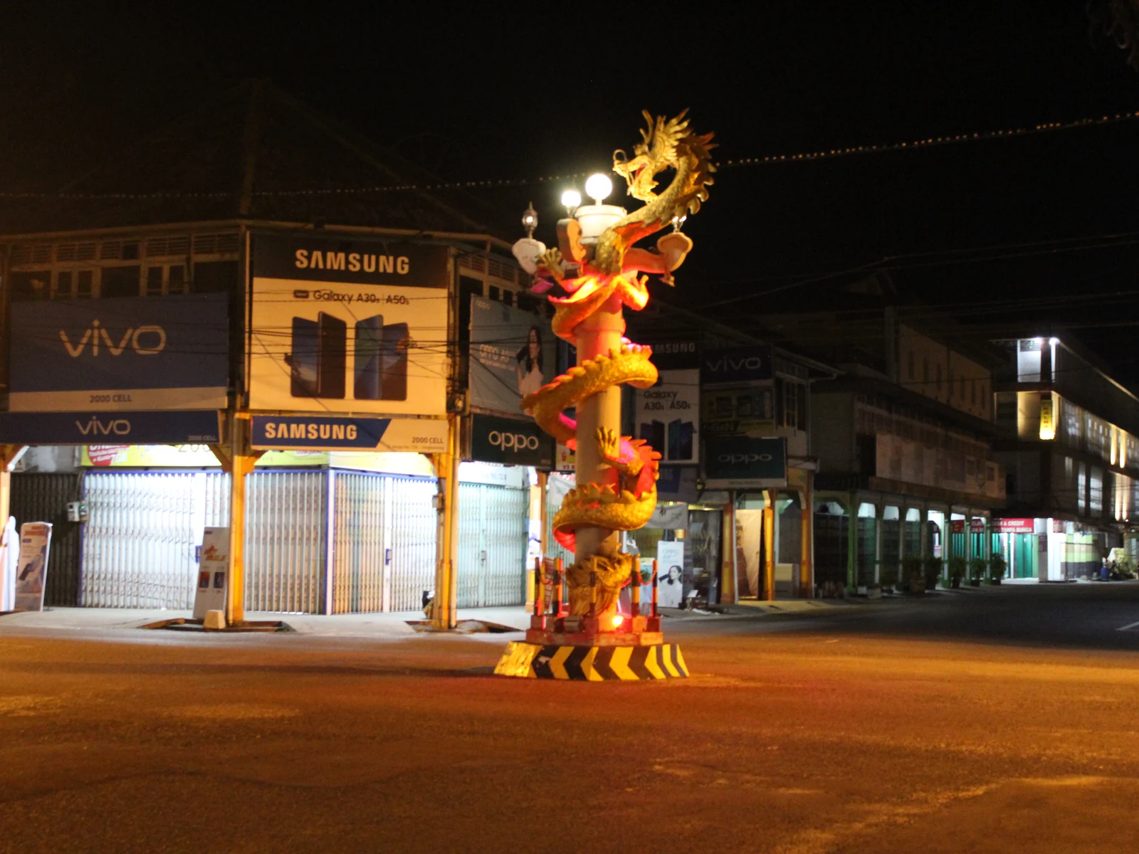 Tugu Naga di tengah persimpangan Jalan Niaga, Singkawang, pada malam hari.